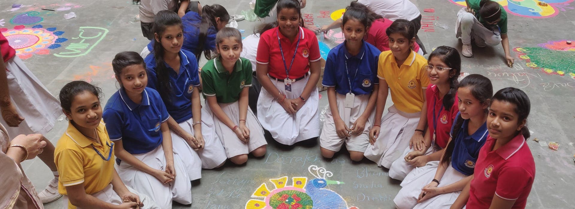 Students creating rangoli floor art